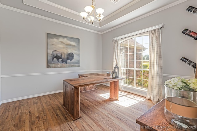 office with ornamental molding, hardwood / wood-style floors, a raised ceiling, and a chandelier