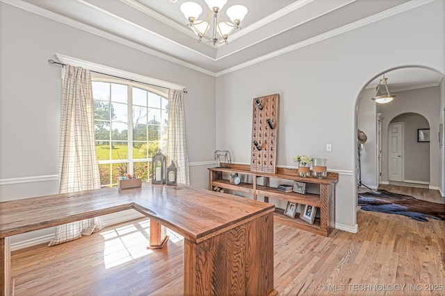 dining space with light hardwood / wood-style floors, crown molding, and a chandelier