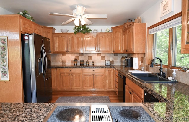 kitchen featuring stainless steel fridge, decorative backsplash, ceiling fan, black dishwasher, and sink