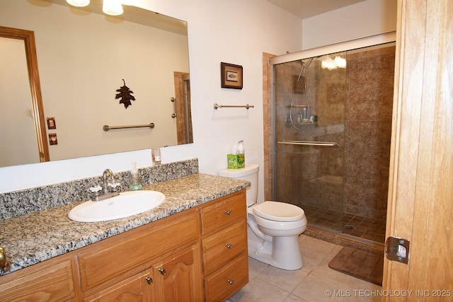 full bathroom with a stall shower, vanity, tile patterned flooring, and toilet