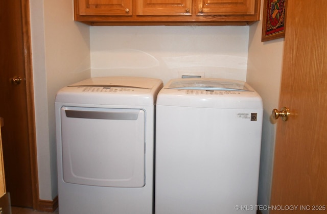 clothes washing area featuring washer and dryer and cabinets