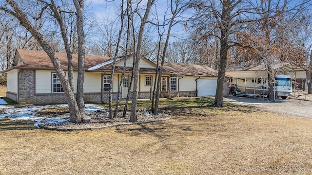 single story home with a carport, a front yard, and a garage