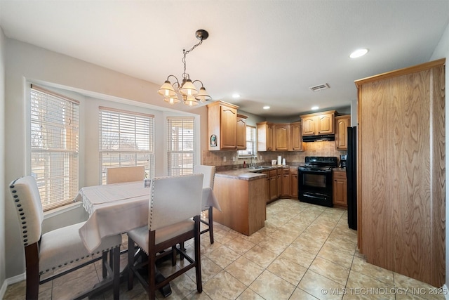 kitchen featuring sink, decorative light fixtures, decorative backsplash, a chandelier, and black appliances