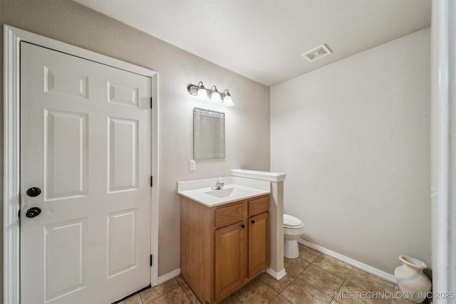 bathroom featuring toilet, tile patterned flooring, and vanity