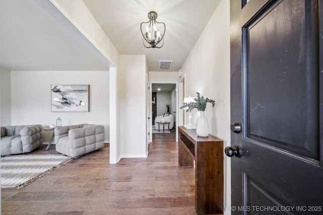 foyer featuring light wood-type flooring and a notable chandelier