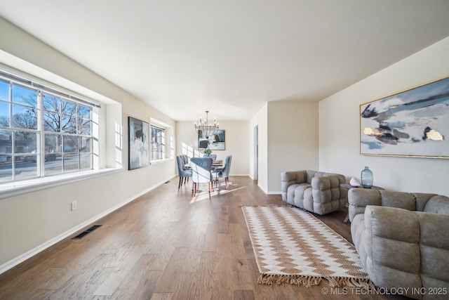 living room with hardwood / wood-style flooring and a notable chandelier