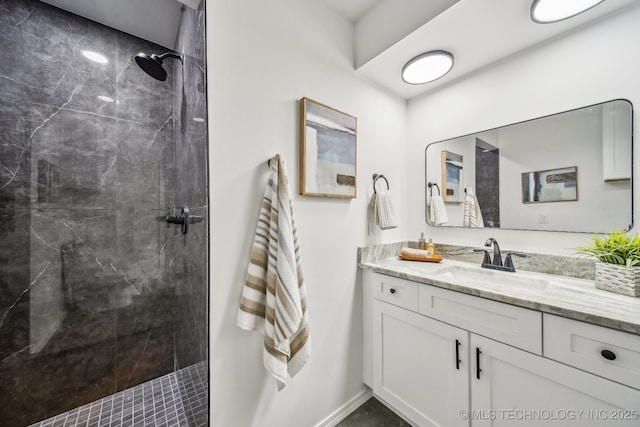 bathroom with a tile shower and vanity