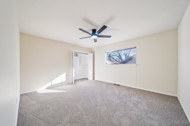 carpeted spare room featuring ceiling fan