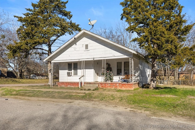 bungalow-style house featuring a front yard, a porch, and cooling unit