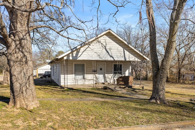 bungalow-style home featuring a porch and a front yard