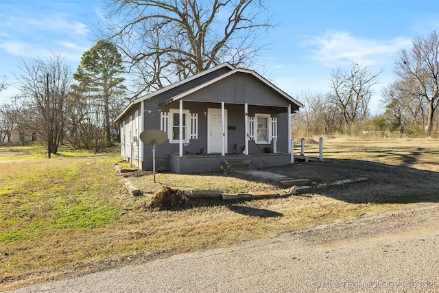 view of front of house with covered porch and a front lawn