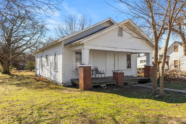 bungalow-style home featuring covered porch and a front lawn