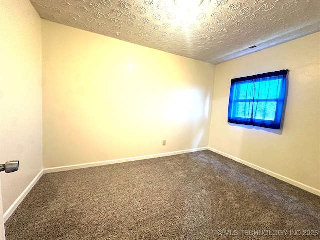 carpeted empty room featuring a textured ceiling