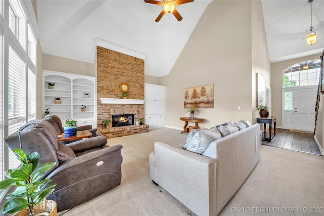 carpeted living room with a brick fireplace, high vaulted ceiling, and ceiling fan