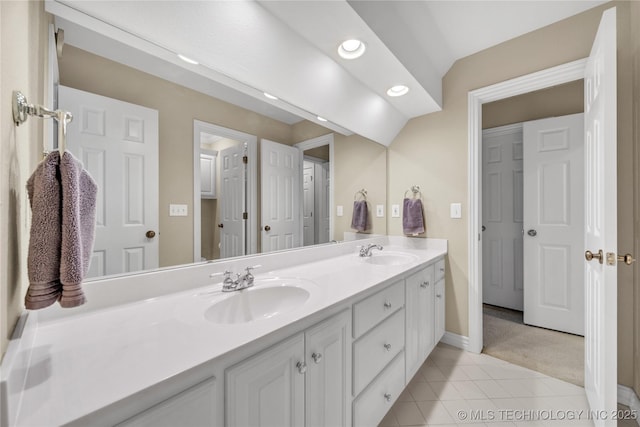 bathroom featuring tile patterned floors, lofted ceiling, and vanity