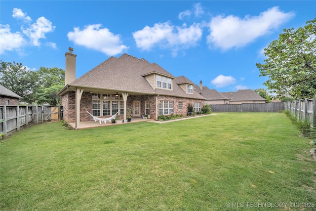 back of house featuring a patio area and a lawn