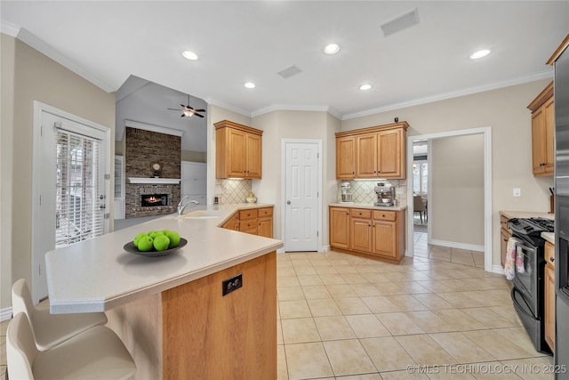 kitchen featuring sink, ceiling fan, light tile patterned floors, decorative backsplash, and gas range