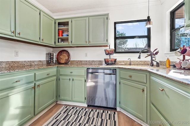 kitchen with light stone countertops, dishwasher, green cabinetry, ornamental molding, and sink