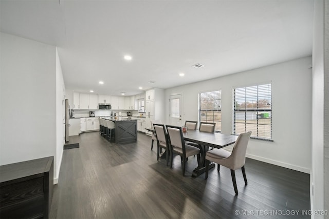 dining space with dark hardwood / wood-style flooring and sink