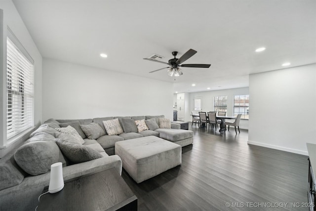 living room with ceiling fan and dark wood-type flooring