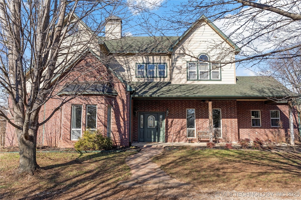 view of front of house featuring covered porch and a front yard