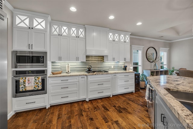 kitchen with stainless steel appliances, white cabinetry, and dark hardwood / wood-style floors