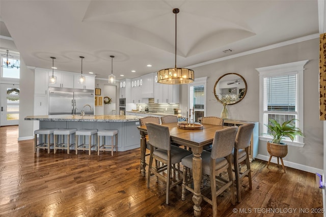 dining area with dark hardwood / wood-style flooring, a chandelier, and crown molding