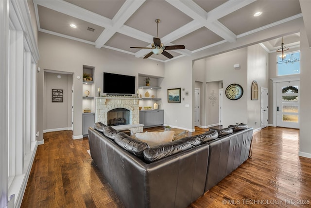 living room with coffered ceiling, beamed ceiling, a fireplace, and built in features