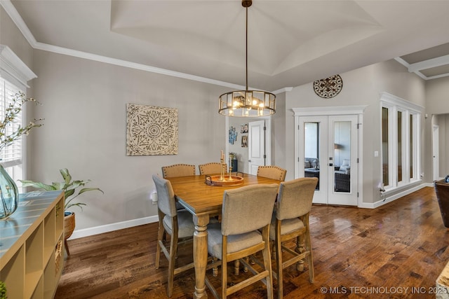 dining room with vaulted ceiling, dark wood-type flooring, an inviting chandelier, and french doors