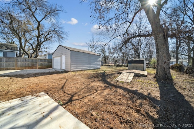 view of yard featuring a garage, an outbuilding, fence, and a storage unit