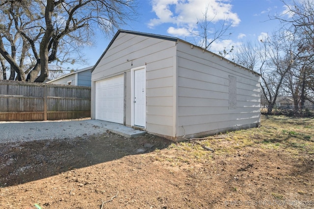 detached garage with driveway and fence