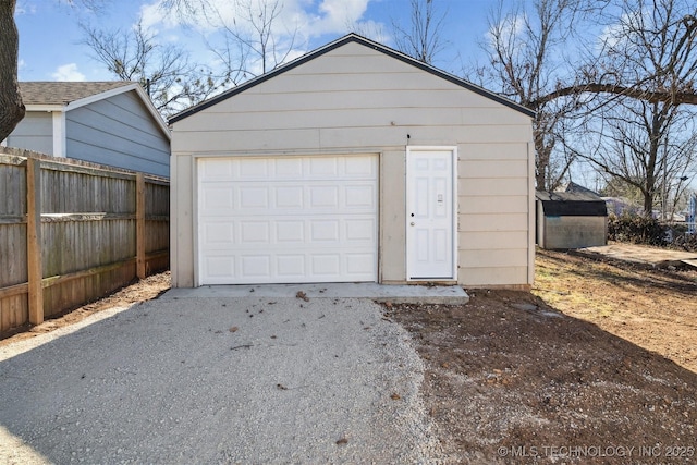 detached garage with driveway and fence