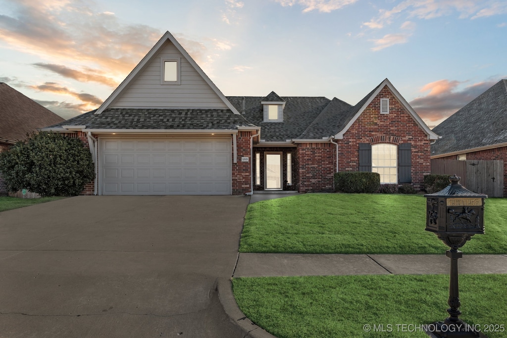 view of front of home with a yard and a garage