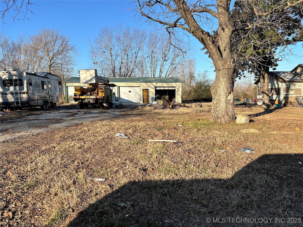 view of yard featuring a garage and an outbuilding