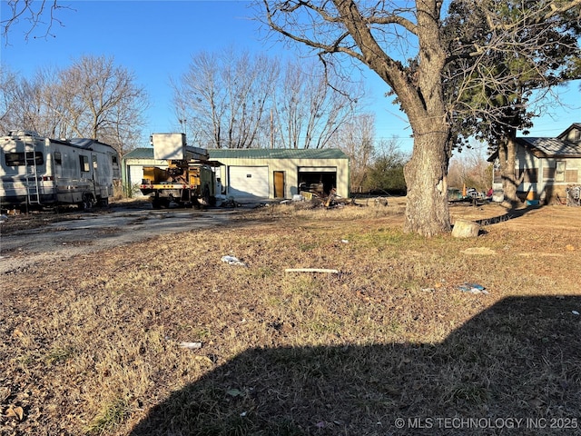 view of yard featuring a garage and an outbuilding