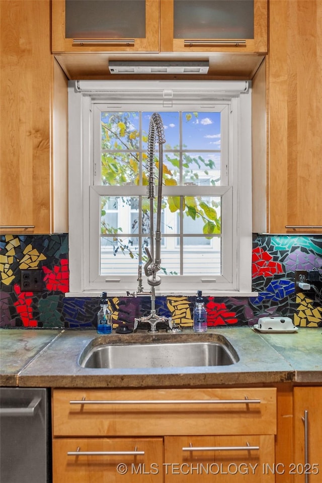 kitchen with a wealth of natural light, stainless steel dishwasher, tasteful backsplash, and sink