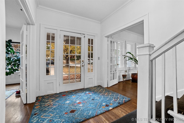 foyer entrance with dark wood-type flooring, ornamental molding, and french doors