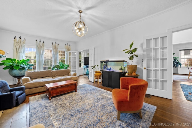 living room featuring crown molding, a chandelier, and a textured ceiling