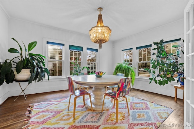 dining room featuring an inviting chandelier, crown molding, and hardwood / wood-style floors