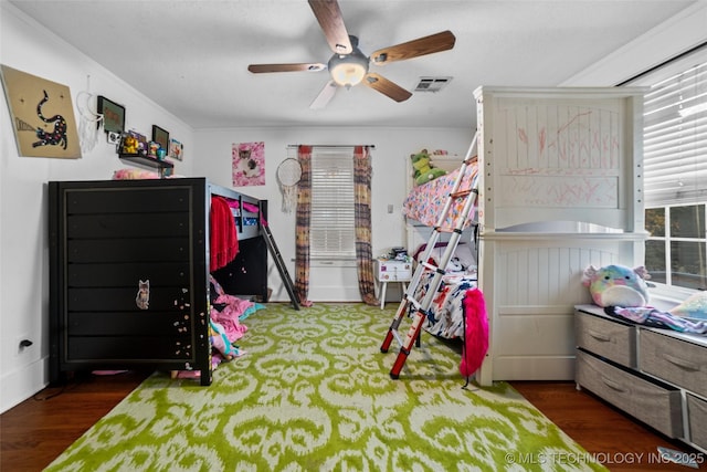 bedroom with ceiling fan, multiple windows, and dark hardwood / wood-style floors