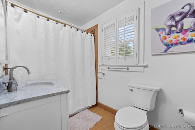 bathroom featuring toilet, vanity, and a shower with shower curtain