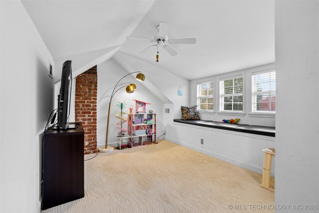 rec room with ceiling fan, vaulted ceiling, and light carpet