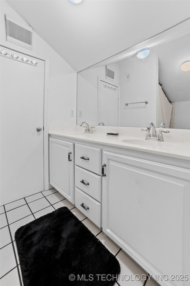 bathroom with lofted ceiling, vanity, and tile patterned floors