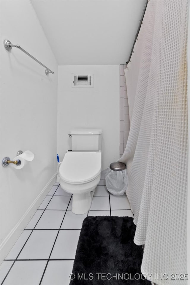 bathroom featuring toilet, vaulted ceiling, and tile patterned floors