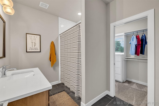 bathroom featuring tile patterned floors, walk in shower, and vanity