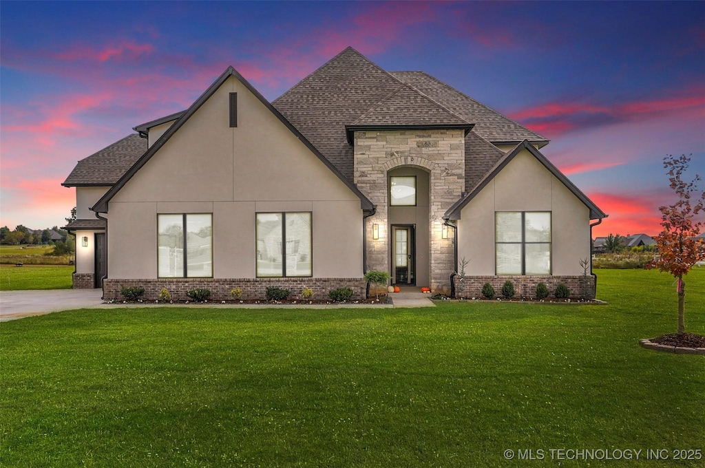 french country style house featuring a lawn