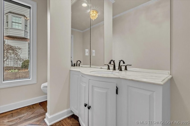 bathroom featuring ornamental molding, toilet, baseboards, and double vanity