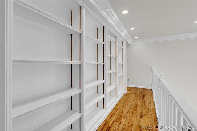 corridor with baseboards, light wood-type flooring, recessed lighting, and crown molding