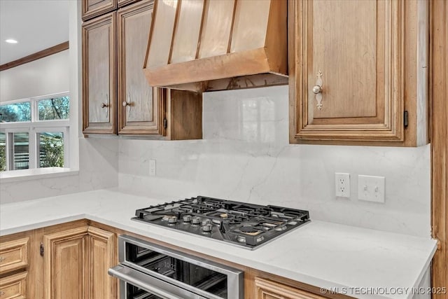 kitchen featuring wall oven, under cabinet range hood, stainless steel gas cooktop, light countertops, and backsplash