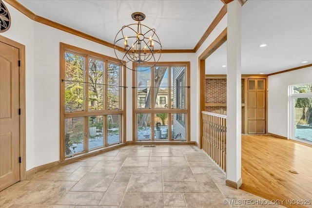 interior space featuring recessed lighting, a notable chandelier, baseboards, ornamental molding, and stone finish flooring